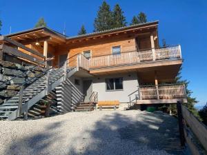 a log house with stairs and a balcony at Sonnenblickhütte in Klippitztorl