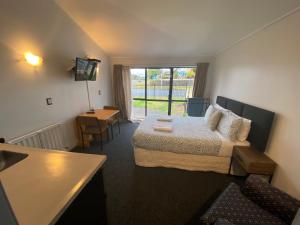 a hotel room with a bed and a television at Ace Motor Lodge in Rotorua