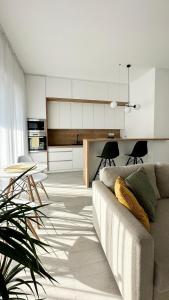 een woonkamer met een bank en een keuken bij Linden Apartman 105 - Adults Only in Mosonmagyaróvár