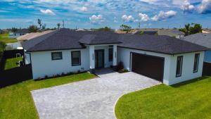 a house with a garage in a residential neighborhood at Corallo House - Heated Pool in Cape Coral