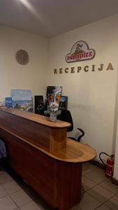 a reception desk at a restaurant with a sign on the wall at Paradize in Daugavpils