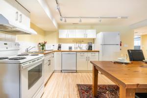 uma cozinha com electrodomésticos brancos e uma mesa de madeira em Cougar Street Mountain Rental em Banff