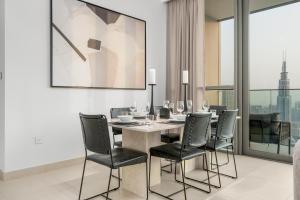 a dining room with a table and black chairs at Ultimate Stay Full Burj Khalifa & Downtown Views Designer Luxury High Floor for 6 People in Dubai