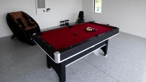 a red pool table with a ball on top of it at Corallo House - Heated Pool in Cape Coral