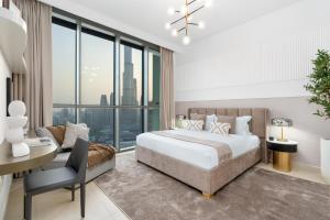 a bedroom with a large bed and a desk and a desk at Ultimate Stay Full Burj Khalifa & Downtown Views Designer Luxury High Floor for 6 People in Dubai