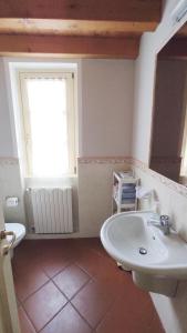 een badkamer met een wastafel en een raam bij Appartamento Cristol in Gargnano