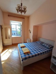 a bedroom with a bed with a blue checkered blanket at Sun city hostel in Yerevan