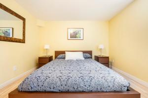 1 dormitorio con 1 cama y 2 mesitas de noche en Cougar Street Mountain Rental en Banff