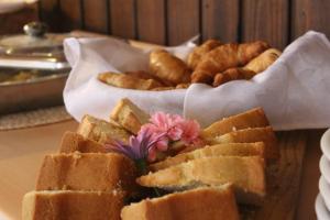 una mesa cubierta con pan y una cesta de bollería en FULL SPA ISLA NEGRA Suites en Isla Negra