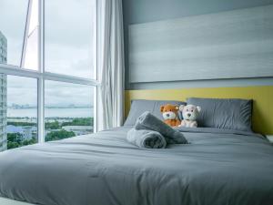 two stuffed animals sitting on top of a bed with a window at Penang Straits Garden Condominium Georgetown in George Town