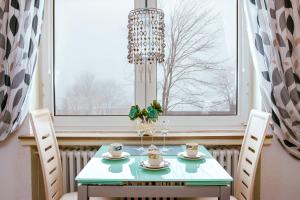 a dining room table with a chandelier in front of a window at Ferienwohnung Marth in Sankt Andreasberg