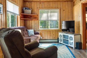 a living room with a couch and a television at Lakefront Marenisco Cabin with Private Dock! in Bergland
