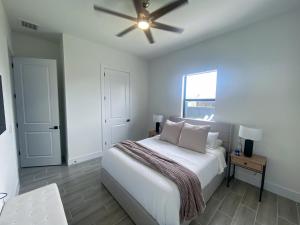 a white bedroom with a bed and a ceiling fan at Corallo House - Heated Pool in Cape Coral +30 photos