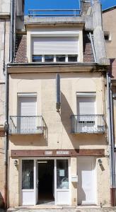 een gebouw met witte deuren en balkons erop bij Hôtel Lamartine in Dijon