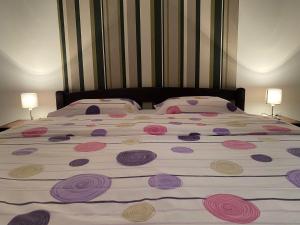 ein großes Bett mit rosa und lila Blumen drauf in der Unterkunft Apartman Kalina in Donje Mladice