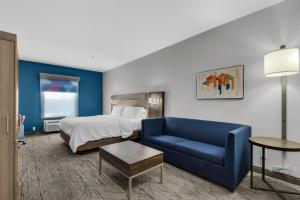 pokój hotelowy z łóżkiem i niebieską kanapą w obiekcie Holiday Inn Express Destin E - Commons Mall Area, an IHG Hotel w mieście Destin