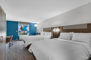 2 camas en una habitación de hotel con paredes azules en Holiday Inn Express Destin E - Commons Mall Area, an IHG Hotel, en Destin