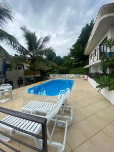 Un patio con dos sillas y una piscina. en Apartamento em Florianópolis, en Florianópolis