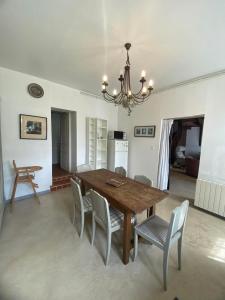 mesa de comedor con sillas y lámpara de araña en La maison du Bec en Normandie, en Le Bec-Hellouin