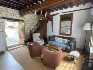 sala de estar con sofá y mesa en La maison du Bec en Normandie, en Le Bec-Hellouin