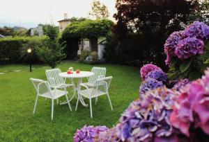 a table and chairs in a yard with purple flowers at Un sorriso sul Viso in Martiniana Po