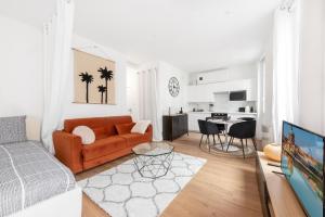 uma sala de estar com um sofá e uma mesa em Appartement moderne à 2 pas de la Gare em Toulouse
