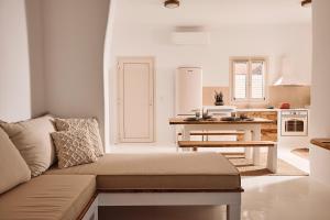 ein Wohnzimmer mit einem Sofa und einer Küche in der Unterkunft Infinity Villa milos in Pachaina