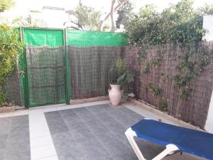 a patio with a blue bench and a fence at tilis מרגולין 33 תל אביב in Tel Aviv