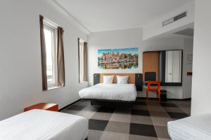 a hotel room with two beds and a table at easyHotel Amsterdam Arena Boulevard in Amsterdam