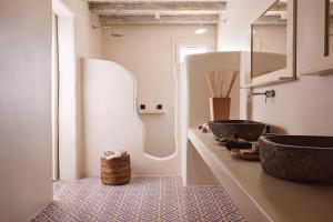 ein Badezimmer mit einem Waschbecken und einem großen Spiegel in der Unterkunft Infinity Villa milos in Pachaina