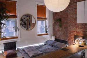 a living room with a couch and a brick wall at Peaceful Japanese Ryokan in the heart West Village in New York