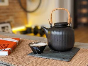 a black tea kettle and a cup on a table at Peaceful Japanese Ryokan in the heart West Village in New York