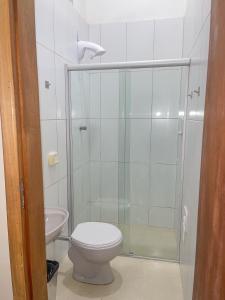 a bathroom with a shower with a toilet and a sink at Poupahotel in Taubaté
