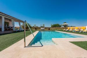 a swimming pool in a yard next to a house at Villa Colona 