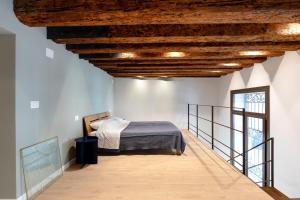 a bedroom with a bed and a wooden ceiling at Maison Revedin in Treviso