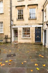 un edificio con una puerta y hojas de otoño en el suelo en Next to Bath Abbey & Roman Baths - Gorgeous Georgian House en Bath