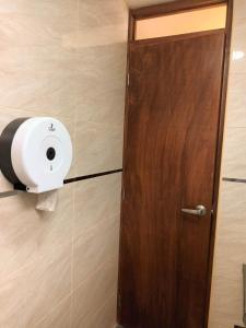 una puerta con un dispensador de toallas de papel en la pared en Habitación 2 camas a pasos del Aeropuerto Lima, en Lima
