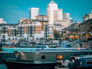 un gruppo di barche ormeggiate in un porto con una città di Cosy 1 Bed Apartment - Canary Wharf, Limehouse a Londra