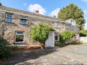 an old stone house with a white door at Quiet Trees in Bodmin