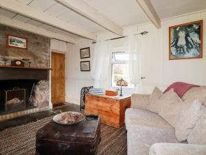 a living room with a couch and a fireplace at Quiet Trees in Bodmin