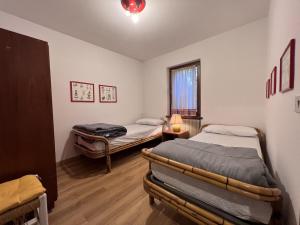 a room with two beds and a window at Appartamenti Residenza Alpina in Pinzolo