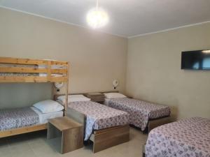 Zimmer mit 3 Betten und einem Flachbild-TV in der Unterkunft Agriturismo Cara Terra Lucana in Chiaromonte