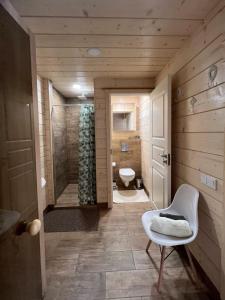 La salle de bains est pourvue de toilettes et d'une douche à l'italienne. dans l'établissement Milkės Karibai - poilsio namelis su sauna ir kubilu, 