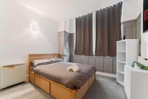 ein Schlafzimmer mit einem Bett und einem großen Fenster in der Unterkunft Spacious City Centre Apartment w/ Free Valet Parking in Leicester