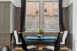 een eetkamer met een tafel en stoelen en een raam bij Spacious City Centre Apartment w/ Free Valet Parking in Leicester