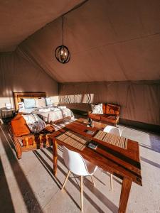 1 dormitorio con 1 cama, mesa y sillas en Aloeron at Patatsfontein Stay en Montagu
