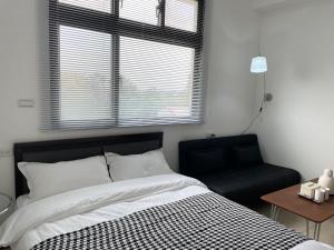 a bedroom with a bed and a chair and a window at 金門且停民宿 可包棟 好停車 近市區 in Jinning