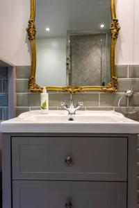 a bathroom with a sink and a mirror at Next to Bath Abbey & Roman Baths - Gorgeous Georgian House in Bath