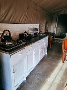 a kitchen with a stove in a tent at Aloeron at Patatsfontein Stay in Montagu