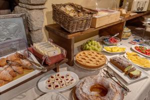 una mesa llena de diferentes tipos de pan y repostería en Convento San Bartolomeo en Abbadia San Salvatore